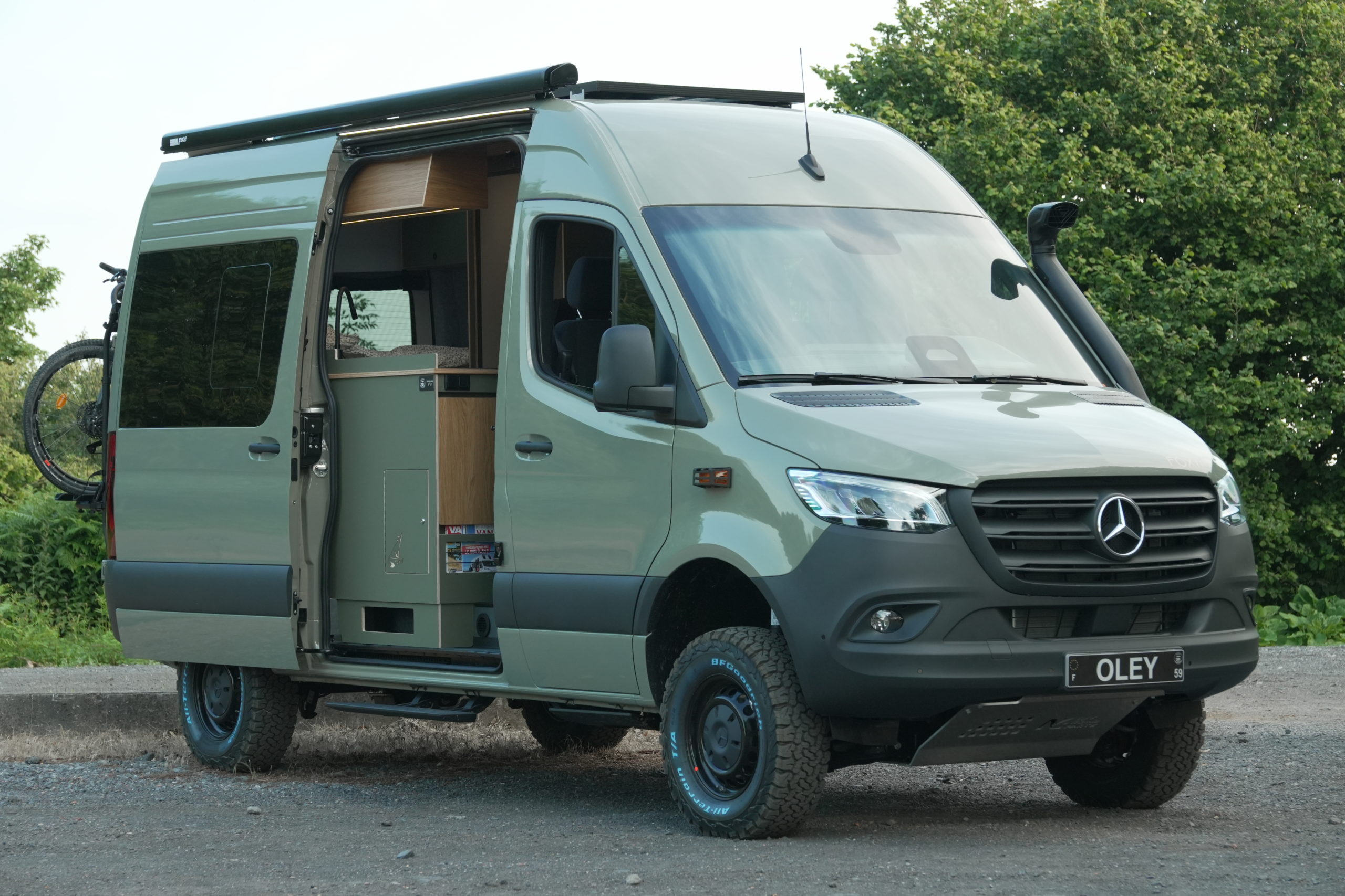Vue 3/4 d’un Mercedes Sprinter 4x4 aménagé avec snorkel et store latéral