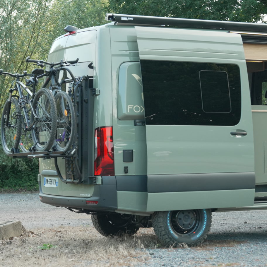 Vue côté passager du Mercedes Sprinter 4x4 avec porte matériel ARMUR, porte-vélo Thule et store Fiamma