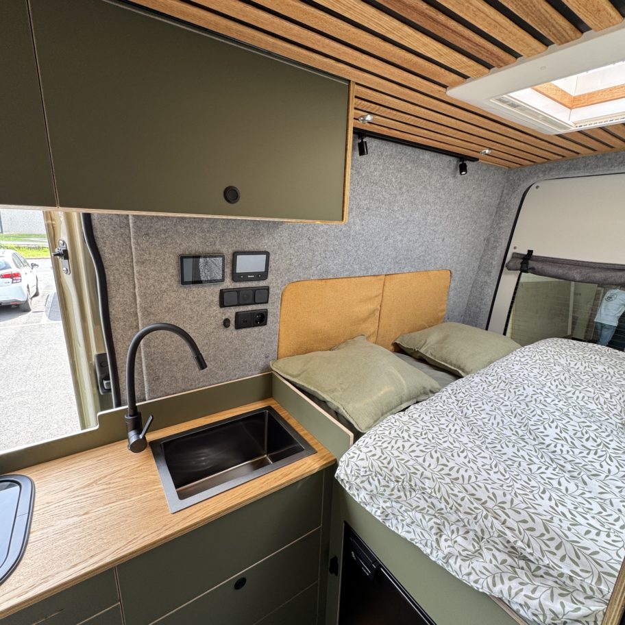 Coin couchage évier de cuisine et écrans de contrôle Victron dans un van aménagé Mercedes Sprinter 4x4