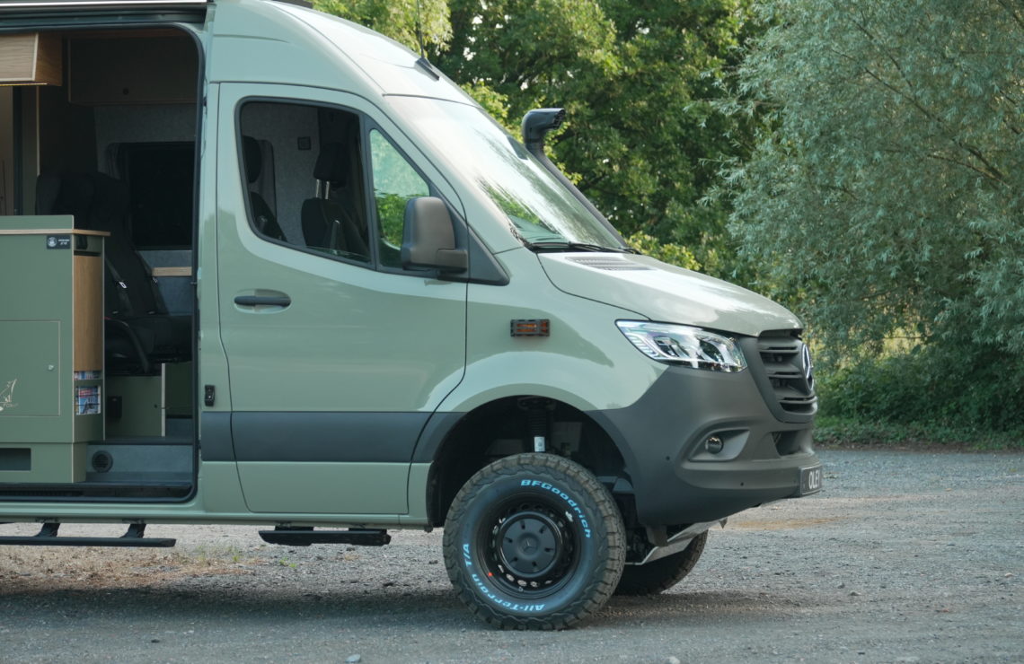 Mercedes Sprinter 4x4 aménagé par Oley Workshop avec porte latérale ouverte et aménagement intérieur visible.
