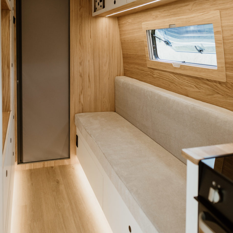 Vue intérieure arrière du fourgon avec banquette et rangements intégrés.