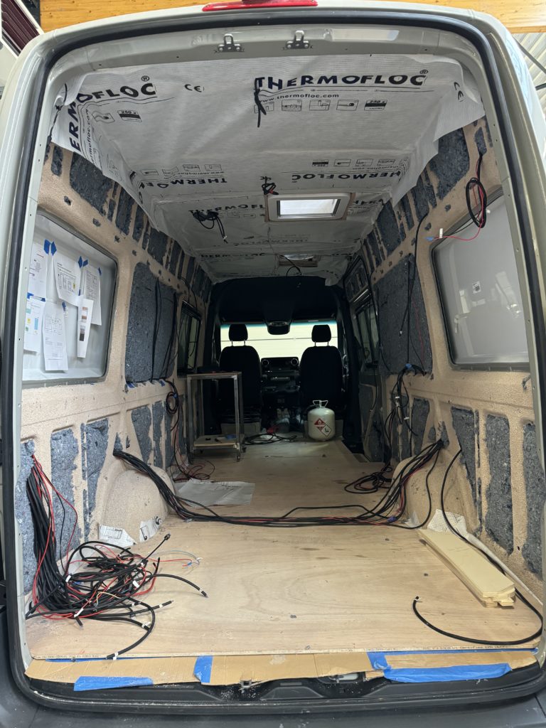 Intérieur d’un fourgon en cours d’isolation et de câblage.