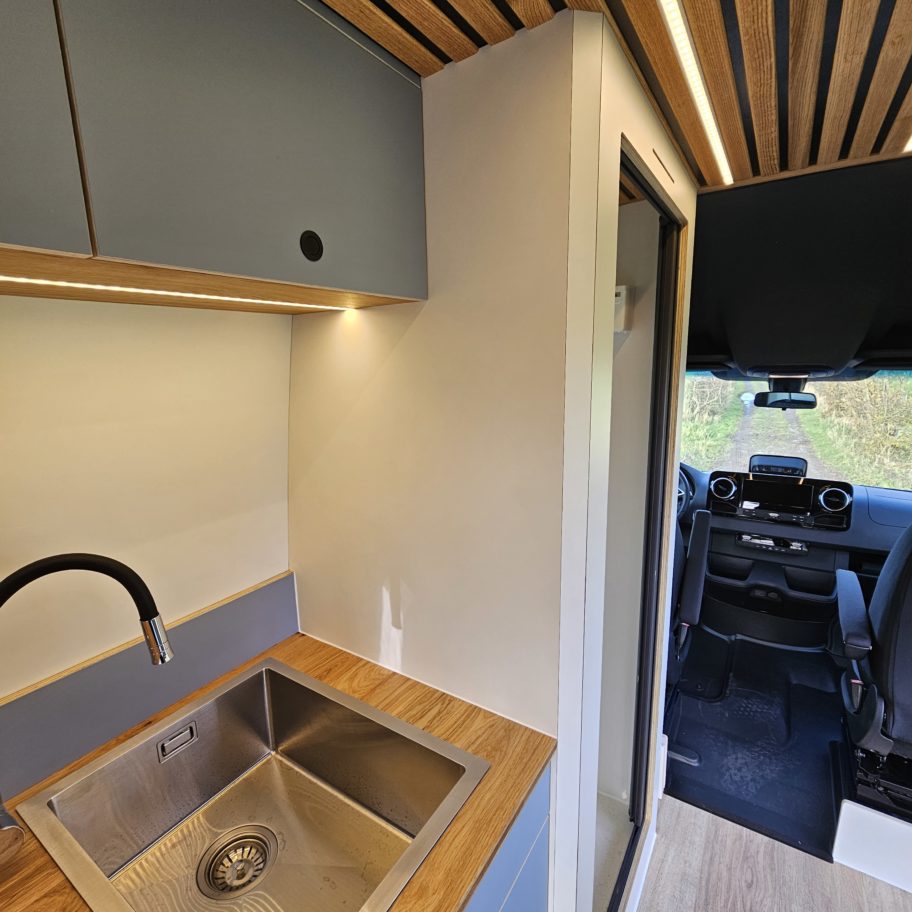 Évier de la cuisine avec robinet noir et éclairage LED.