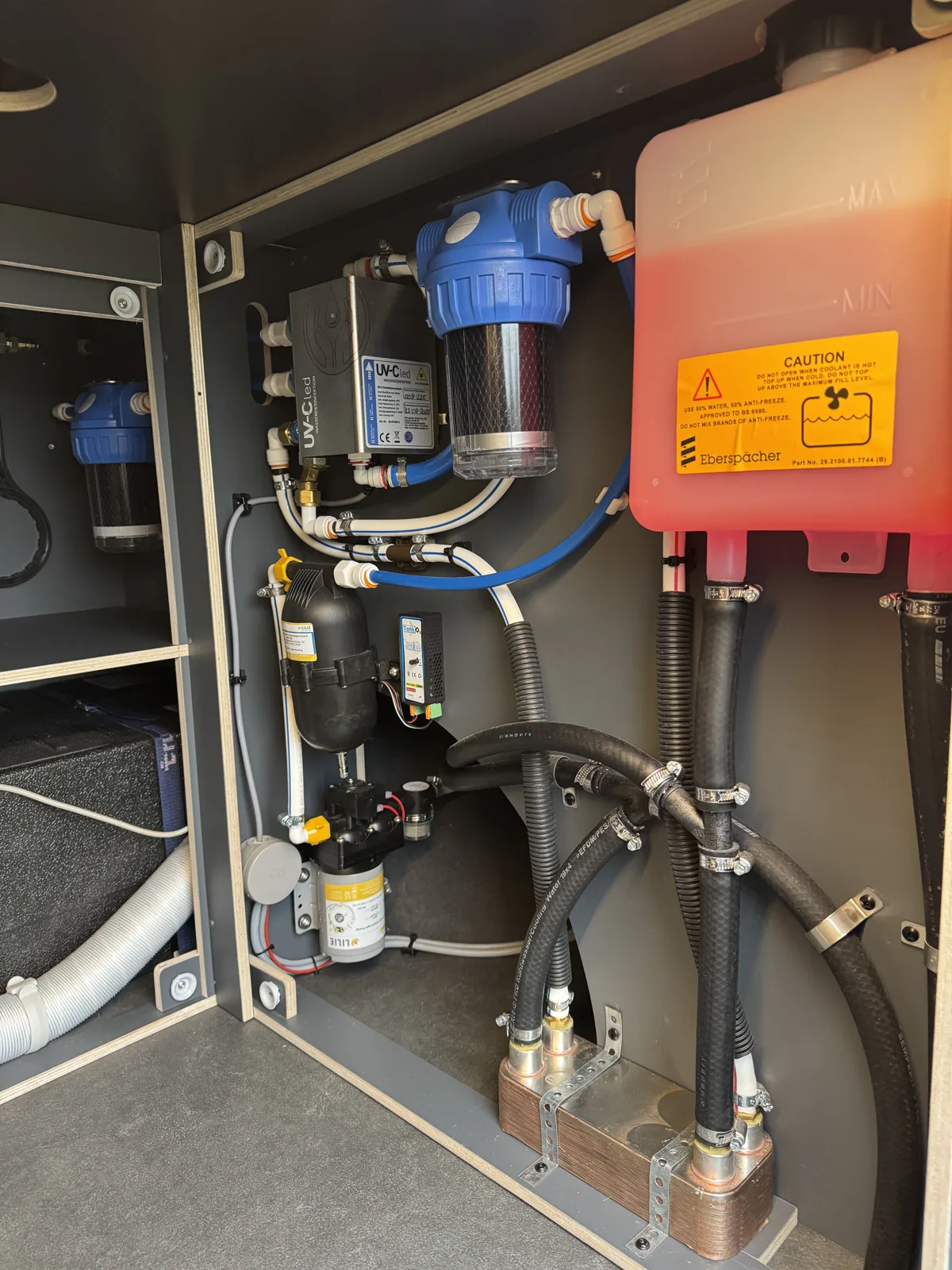 Soute technique d'un fourgon aménagé : circuit d'eau chaude Eberspächer avec échangeur, filtration et vase d'expansion
