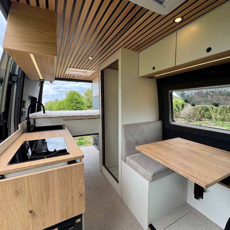 Intérieur d’un fourgon aménagé sur-mesure par Oley Workshop à Lille, avec mobilier artisanal, rangements optimisés et design personnalisé pour la van life.